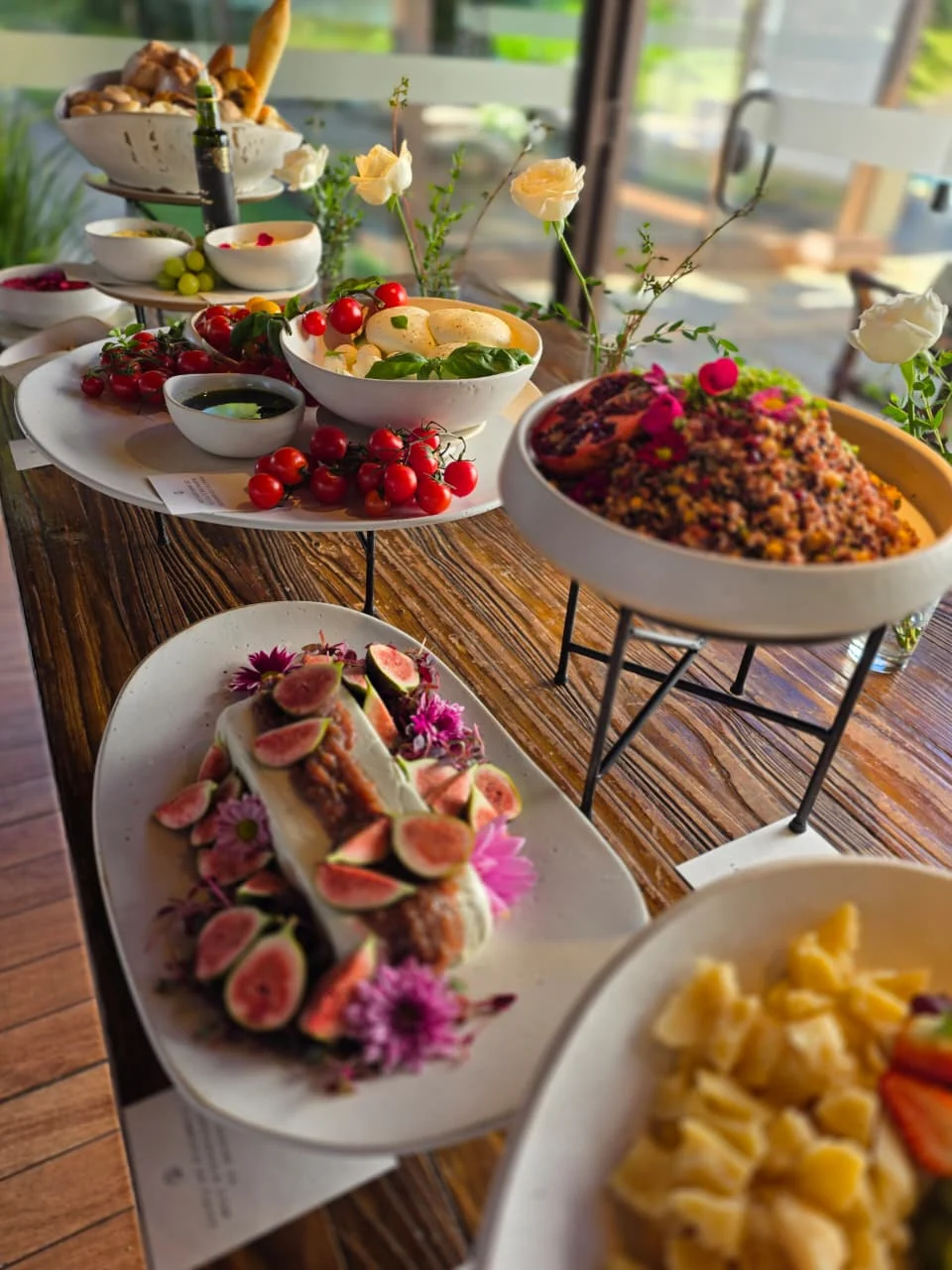 Mesa de buffet completa preparada pela Daniele, com tábua de figos e uvas, salgados e suco natural