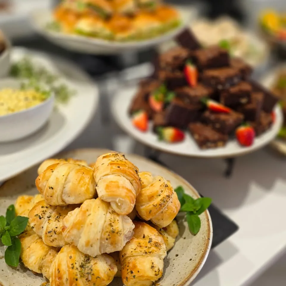 Pãezinhos artesanais polvilhados com ervas ao lado de brownies