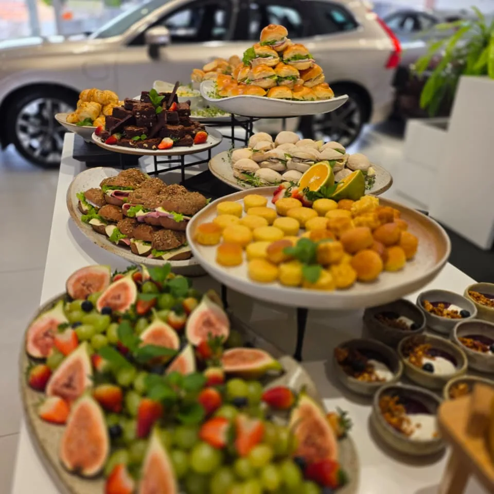 Mesa de buffet com tábua de figos, uvas e salgados variados